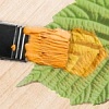 Abb. Farbe wird mit einem Pinsel auf ein Blatt aufgetragen