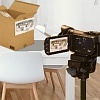 Abb. Camcorder auf Stativ vor Karton Abb. Camcorder auf Stativ vor Karton